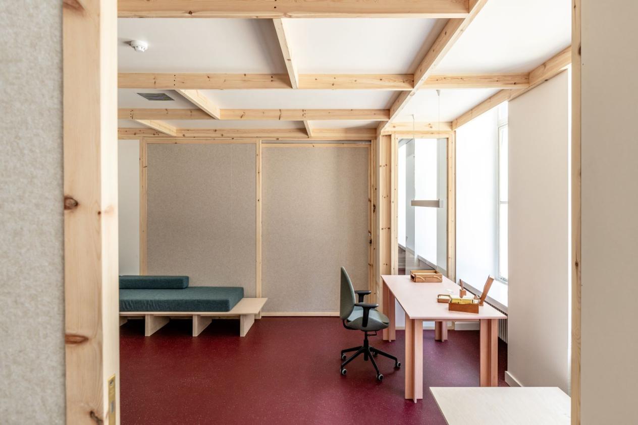 Schrijfkamer langs met bureau, zitbank en lage tafel