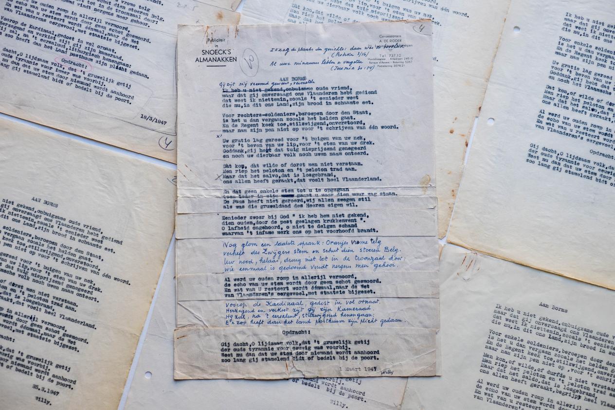 Verspreid over de tafel liggen verschillende vellen papier met diverse versies van het 'Borms'-gedicht.