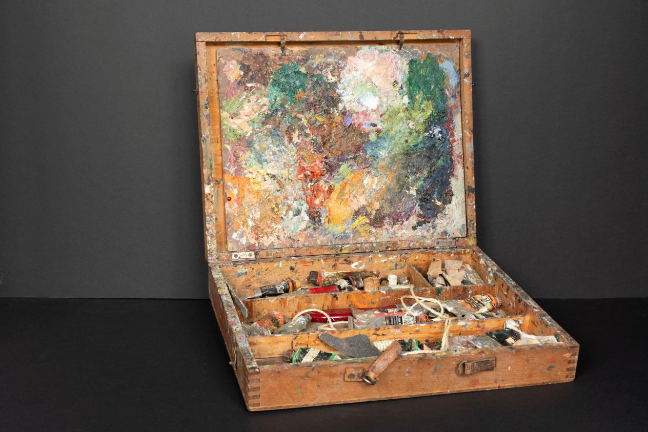 Schildersdoos vol kleurrijke verfspetters met verftubes