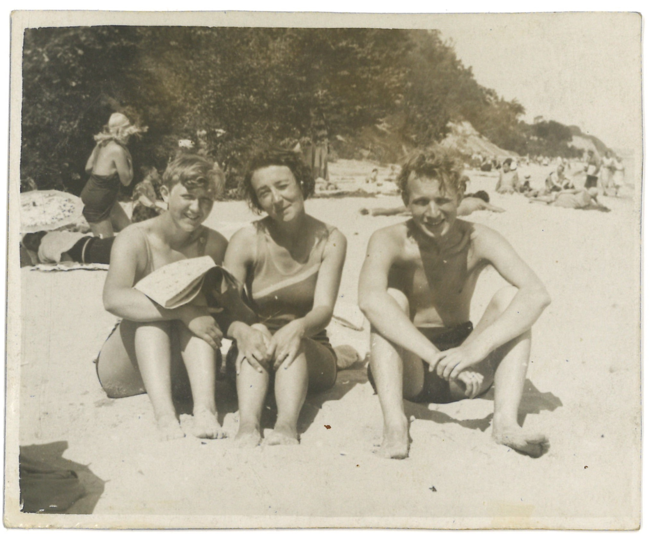 Een foto van Adèle de Ridder, haar man Bennek en vermoedelijk Benneks zus Barbara op het strand in 1932. Ze zitten op een rijtje naast elkaar in het zand en kijken naar de camera.