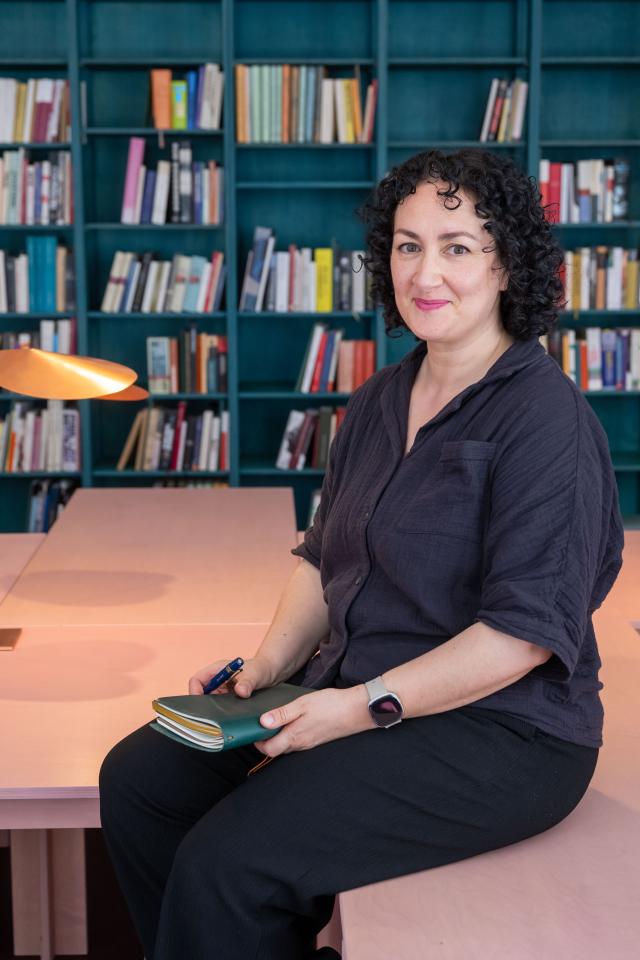 Portretfoto van Abbie Boutkabout, zittend op een tafel in de leeszaal