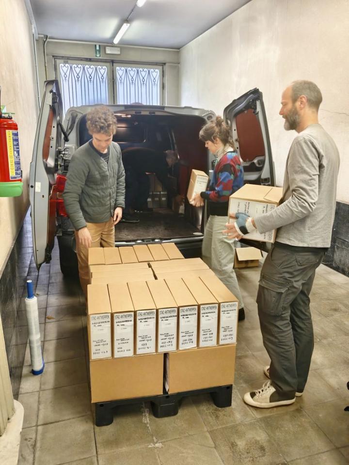 De uitwisseling van de collectie in volle gang. Het archief van Maurits Van Haegendoren wordt door 3 personen in een bestelwagen geladen om naar het ADVN te vervoeren.
