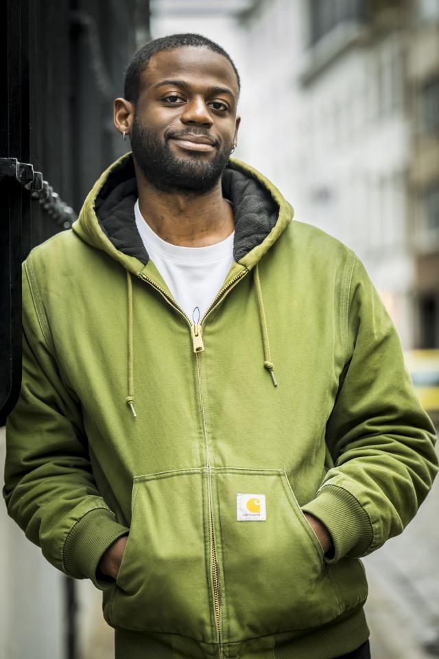 Portretfoto van Will-Limba Moleka leunend tegen de voorgevel van het Letterenhuis