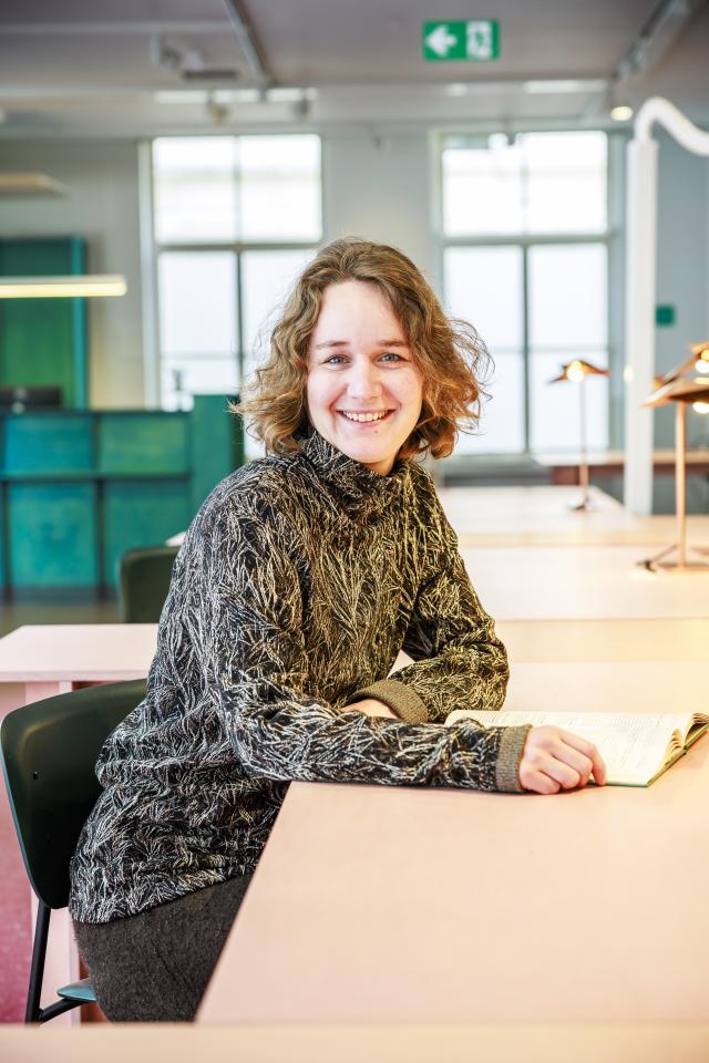 Profielfoto van Astrid Boden, zittend aan een tafel in de leeszaal