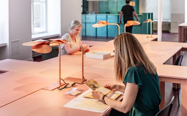 Twee dames in de leeszaal, beide bekijken ze archiefstukken