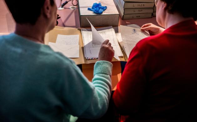 Twee dames bestuderen archiefstukken in de leeszaal