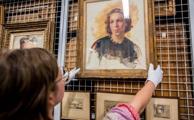 Een medewerker van het Letterenhuis haalt een schilderij uit het archief