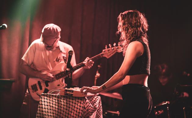 Een vrouw speelt synthesizer en een man elektrische basgitaar.
