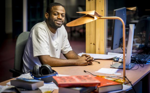 Portretfoto van Will-Limba Moleka aan de schrijftafel in het Seizoensatelier