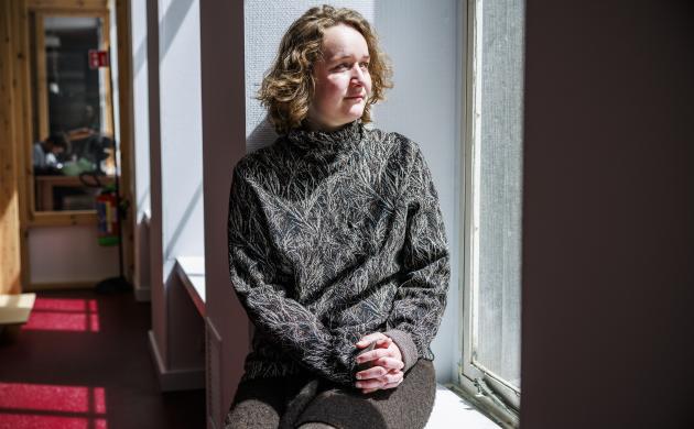 Profielfoto van Astrid Boden, zittend op een vensterbank in het Letterenhuis