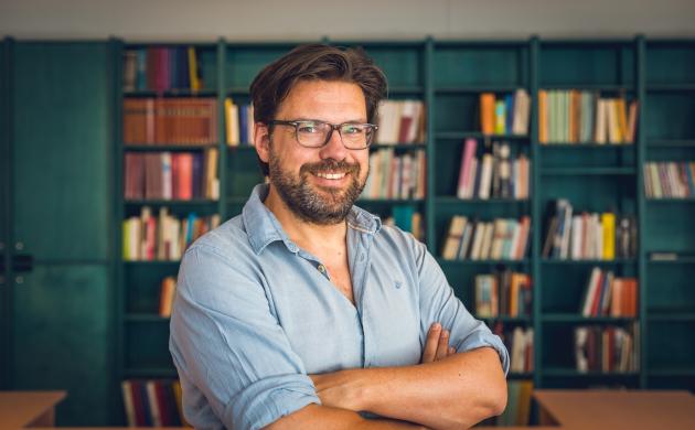 Portretfoto van Philippe Verkinderen in de leeszaal van het Letterenhuis