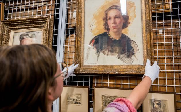 Een medewerker van het Letterenhuis haalt een schilderij uit het archief