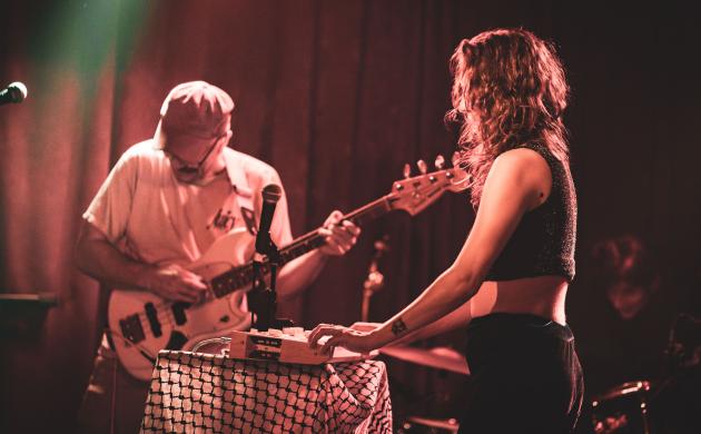 Een vrouw speelt synthesizer en een man elektrische basgitaar.