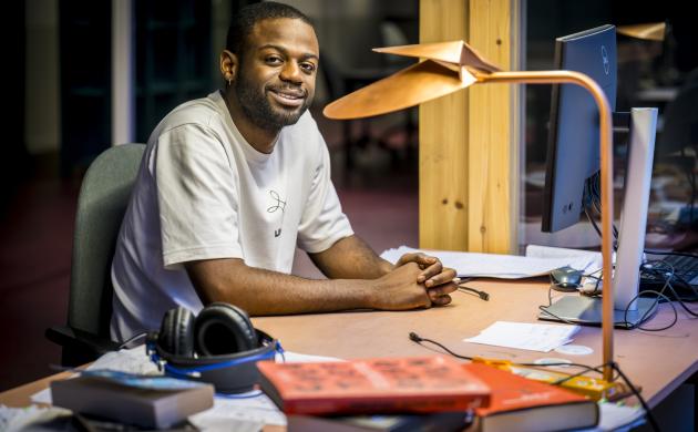 Portretfoto van Will-Limba Moleka aan de schrijftafel in het Seizoensatelier