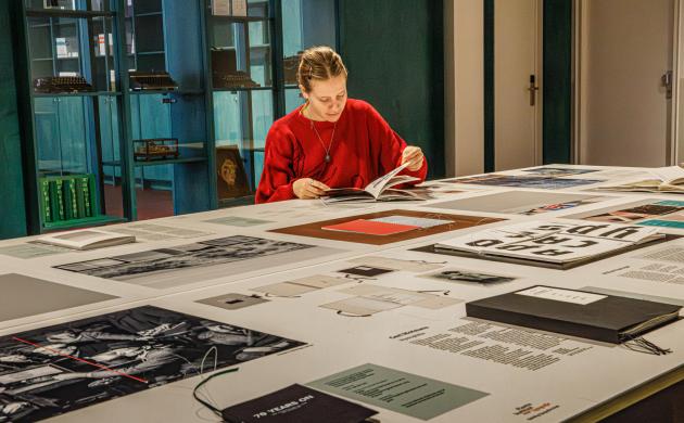 Expo Van letter tot boek - Plantin Instituut voor Typografie (2026) - een jonge vrouw bekijkt een aantal boekontwerpen bekijken 