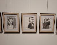 4 houten kaders aan de muur met auteursportretten in houtskool