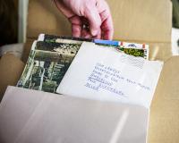 om Lanoye (handen) met doos waarin handschrift en documenten over de roman 'Kartonnen dozen' in bewaard wordt.