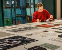 Expo Van letter tot boek - Plantin Instituut voor Typografie (2026) - een jonge vrouw bekijkt een aantal boekontwerpen bekijken 